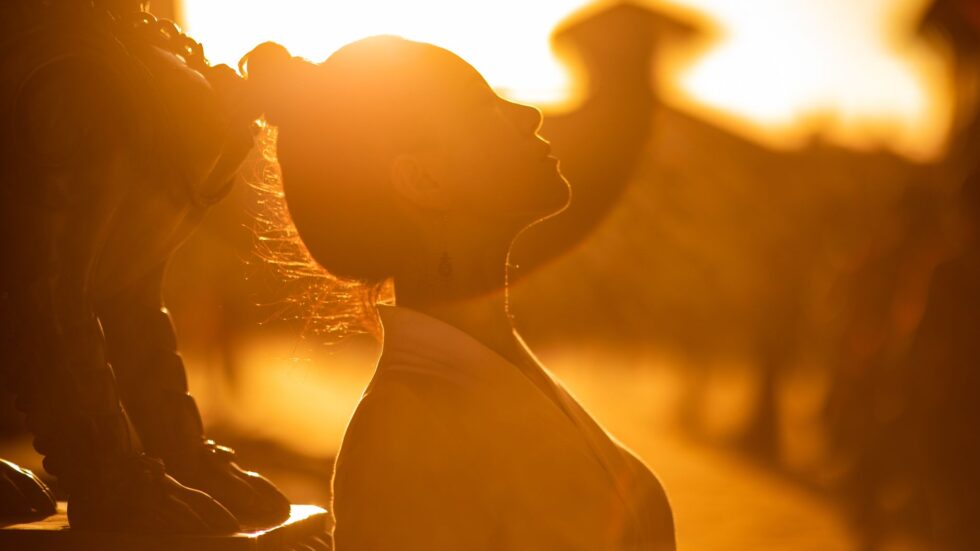 Silhouette dorata di una donna al tramonto, con una luce calda e avvolgente