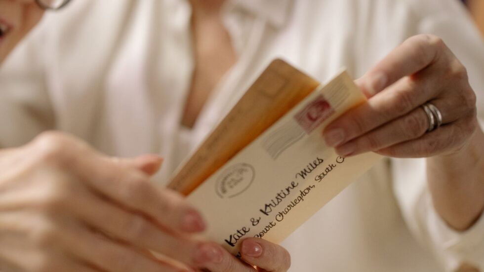 Due mani aprono con delicatezza una lettera d'amore vintage