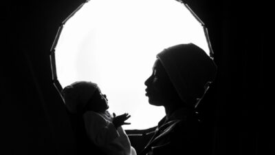 Silhouette in bianco e nero di una madre che tiene in braccio il suo bambino