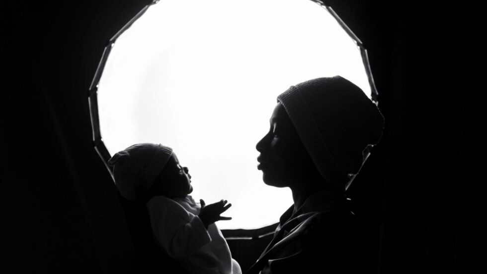 Silhouette in bianco e nero di una madre che tiene in braccio il suo bambino