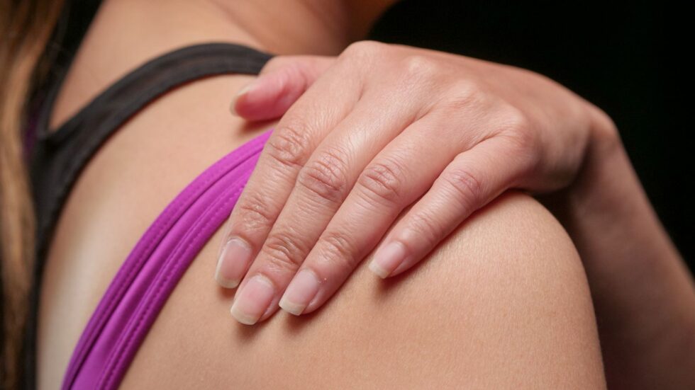 Una mano appoggiata delicatamente su una spalla, in un gesto di calma e conforto